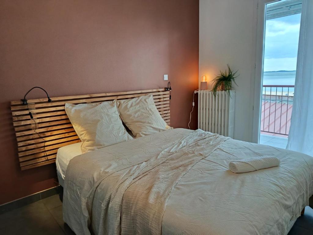 a bedroom with a large white bed with a window at Chti Moutchico in Lacanau