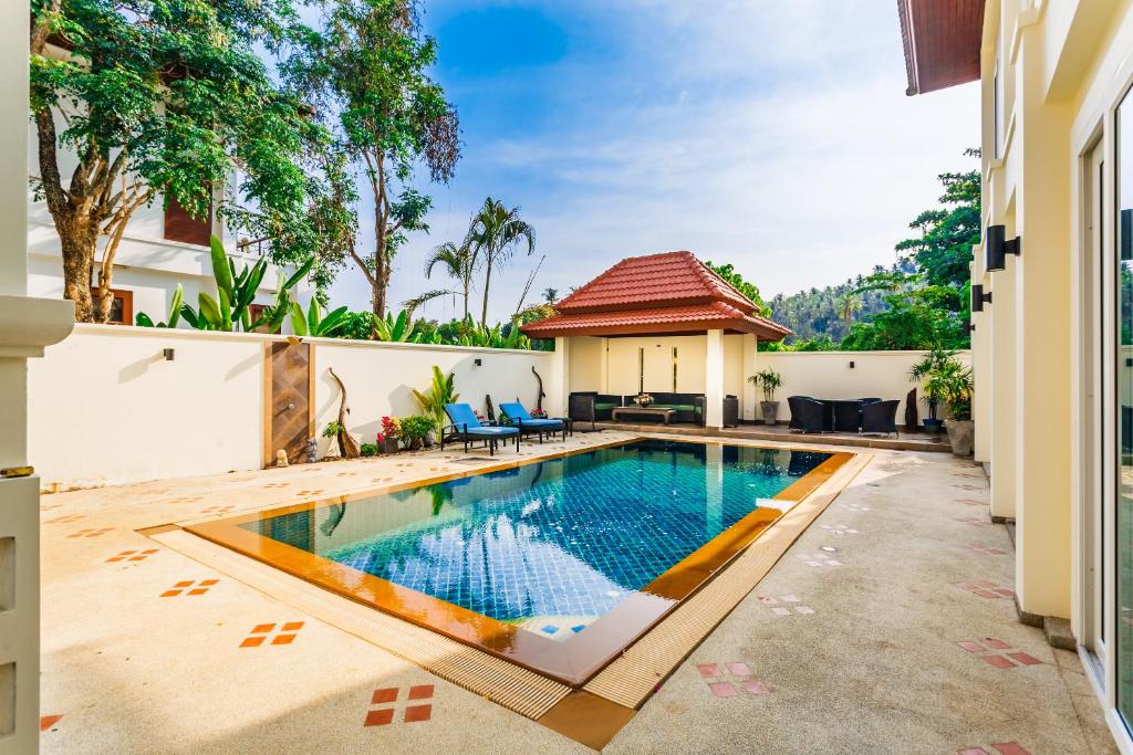 a swimming pool in the backyard of a house at Baan Kaja Villa by Lofty in Surin Beach