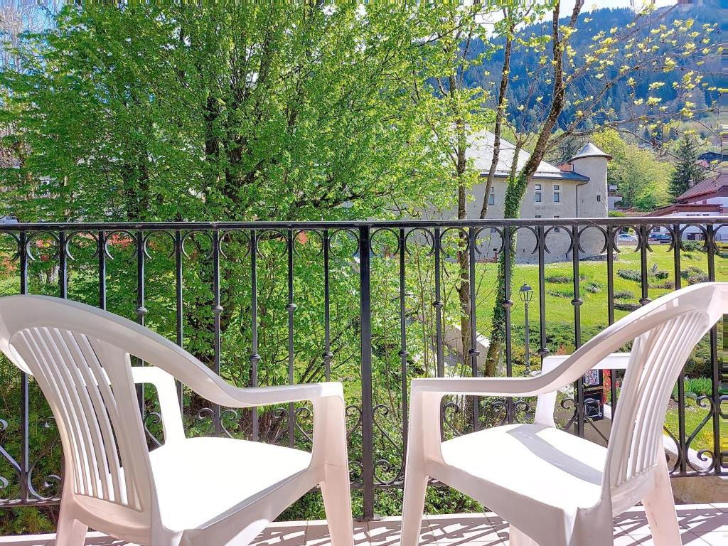 2 chaises blanches assises sur un balcon avec une clôture dans l'établissement Apartment Conseil 3 by Interhome, à Saint-Gervais-les-Bains