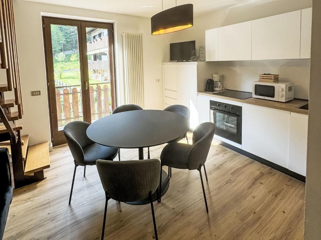 kuchnia ze stołem i krzesłami w pokoju w obiekcie Apartment Dromaè-1 by Interhome w mieście Mezzolago