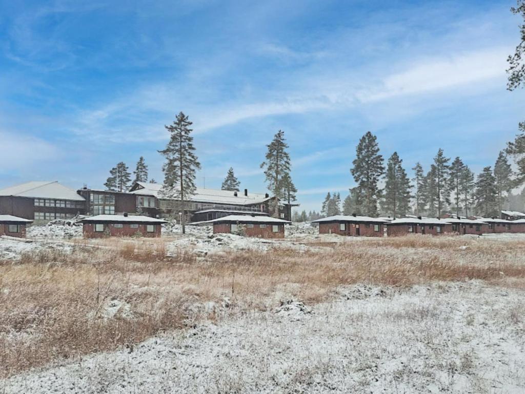 un groupe de bâtiments dans un champ enneigé dans l'établissement Holiday Home Huhmari 14 by Interhome, à Polvijärvi