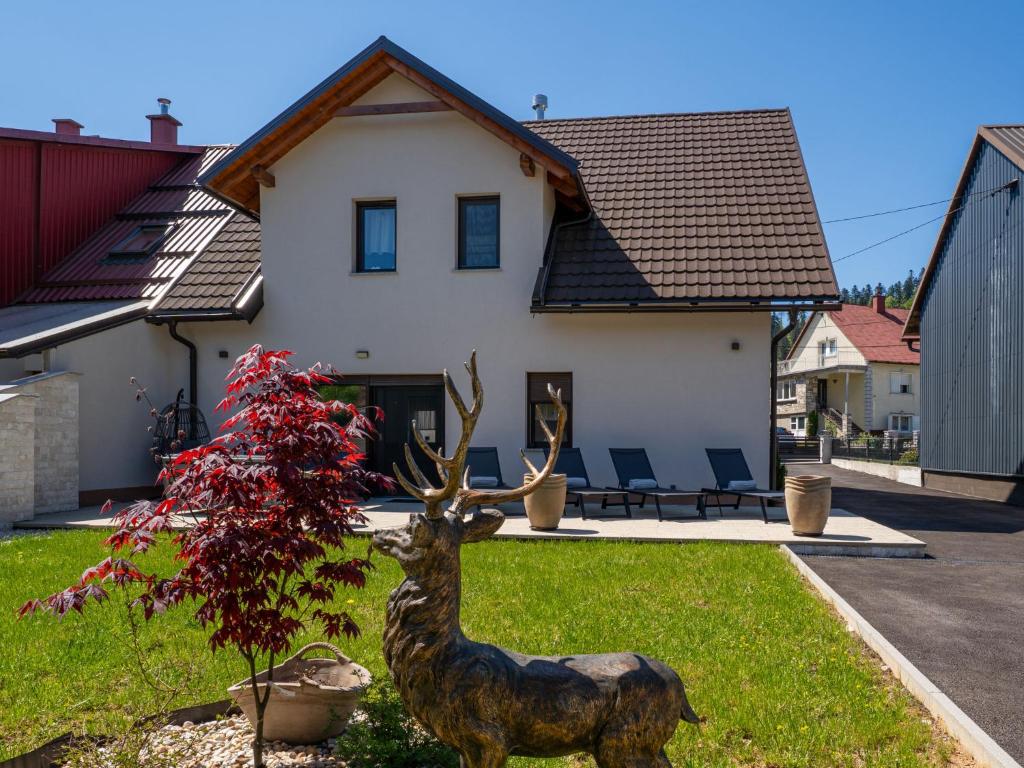 a statue of a deer in front of a house at Holiday Home Holiday House Arni by Interhome in Delnice