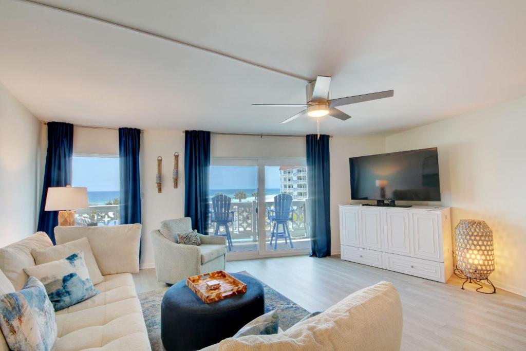a living room with a couch and a ceiling fan at El Matador 344 - Beautiful views of the Gulf and pool in Fort Walton Beach