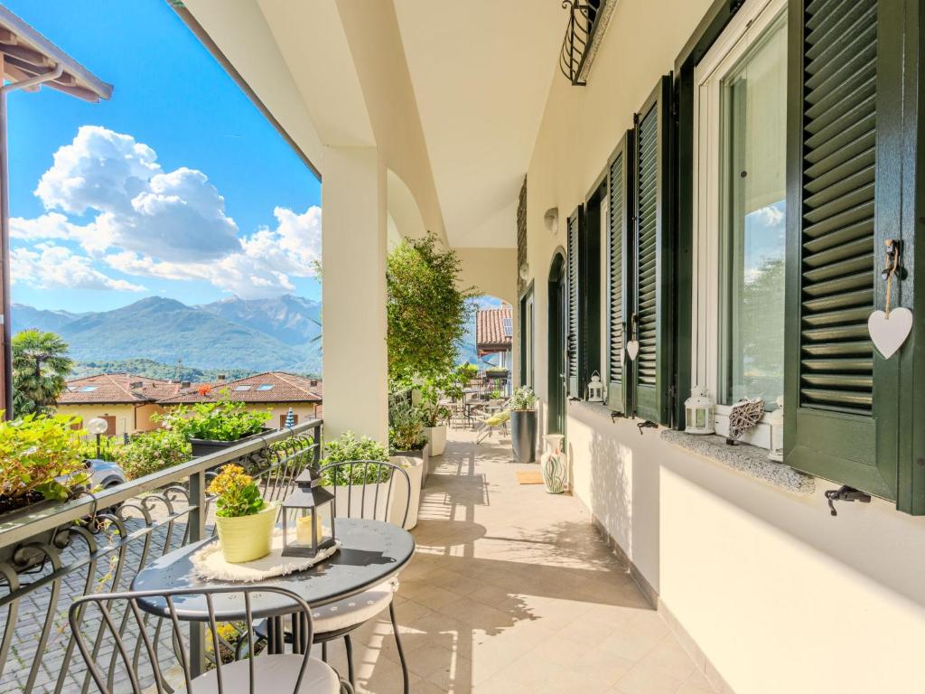 d'un balcon avec des tables et des chaises et une vue sur les montagnes. dans l'établissement Holiday Home Aurora by Interhome, à Colico