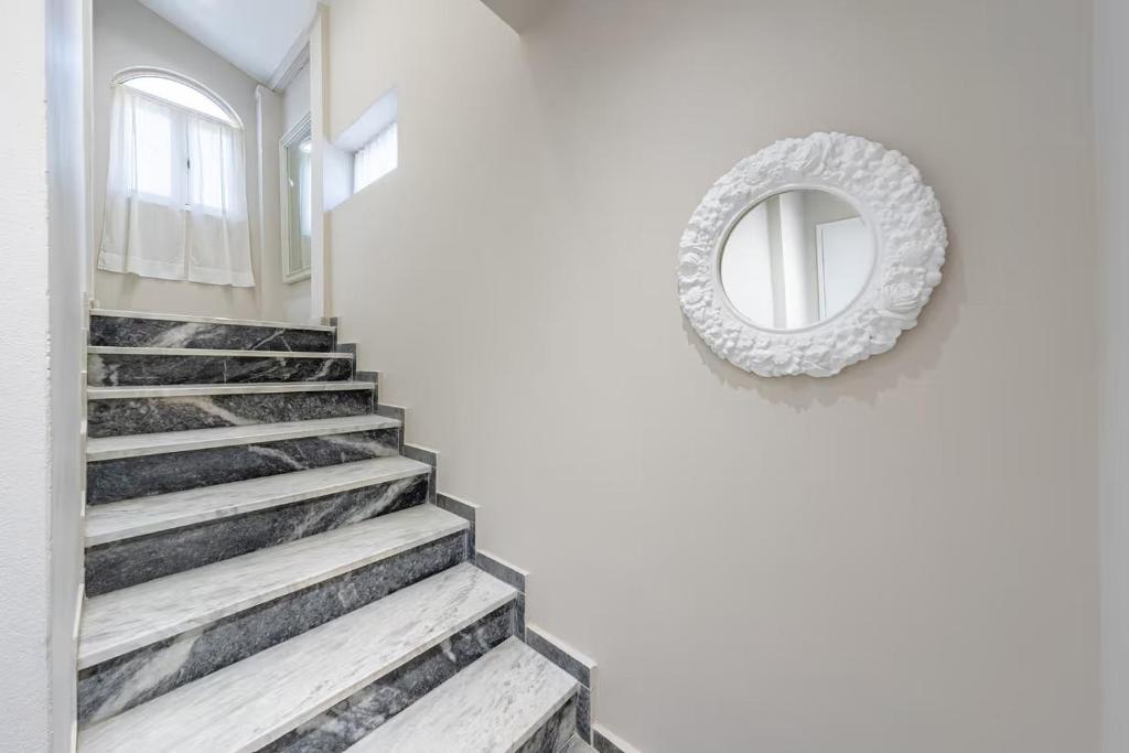 a stairway with a mirror on a wall next to a staircase at Donna's luxury home in Kassiopi 300m from the sea in Kassiopi