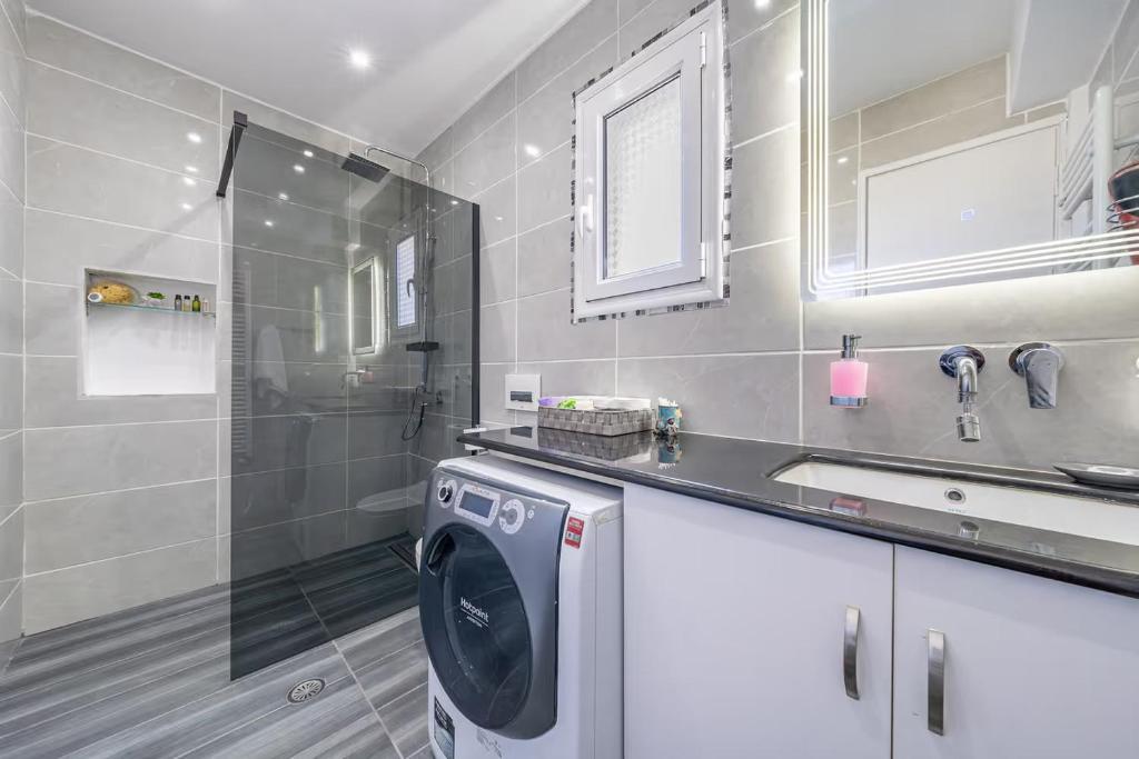 a bathroom with a washing machine and a sink at Donna's luxury home in Kassiopi 300m from the sea in Kassiopi