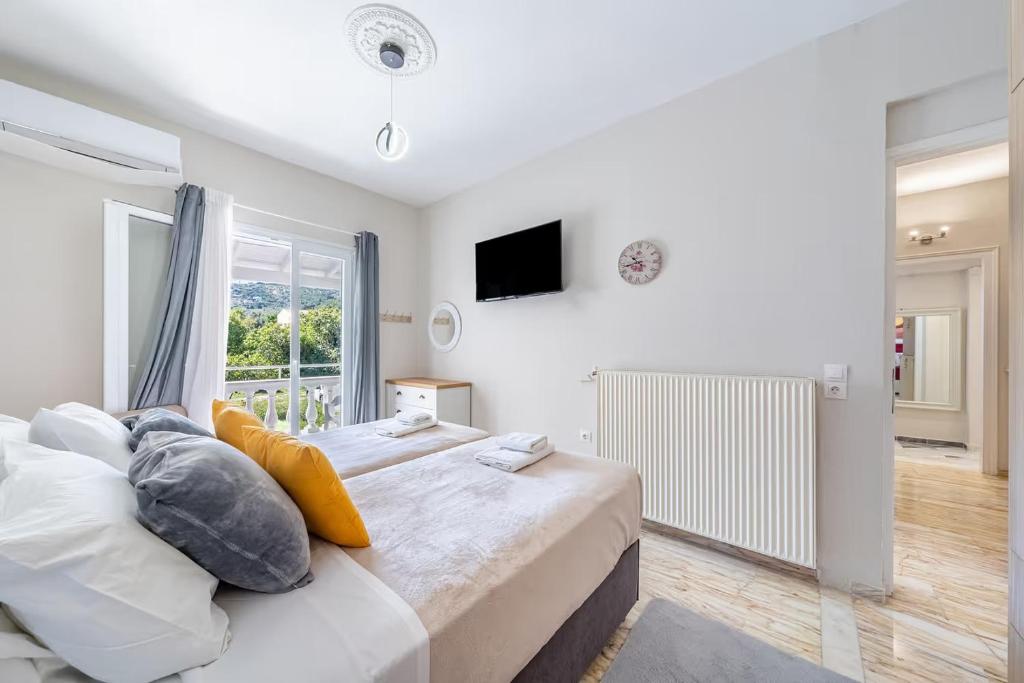 a bedroom with a large bed and a window at Donna's luxury home in Kassiopi 300m from the sea in Kassiopi