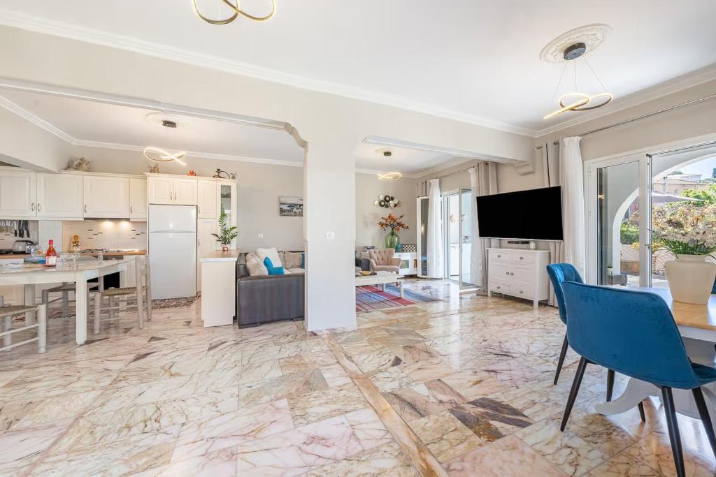 a kitchen and living room with a table and chairs at Donna's luxury home in Kassiopi 300m from the sea in Kassiopi