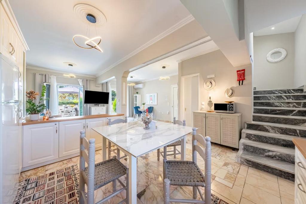a kitchen and dining room with a table and chairs at Donna's luxury home in Kassiopi 300m from the sea in Kassiopi