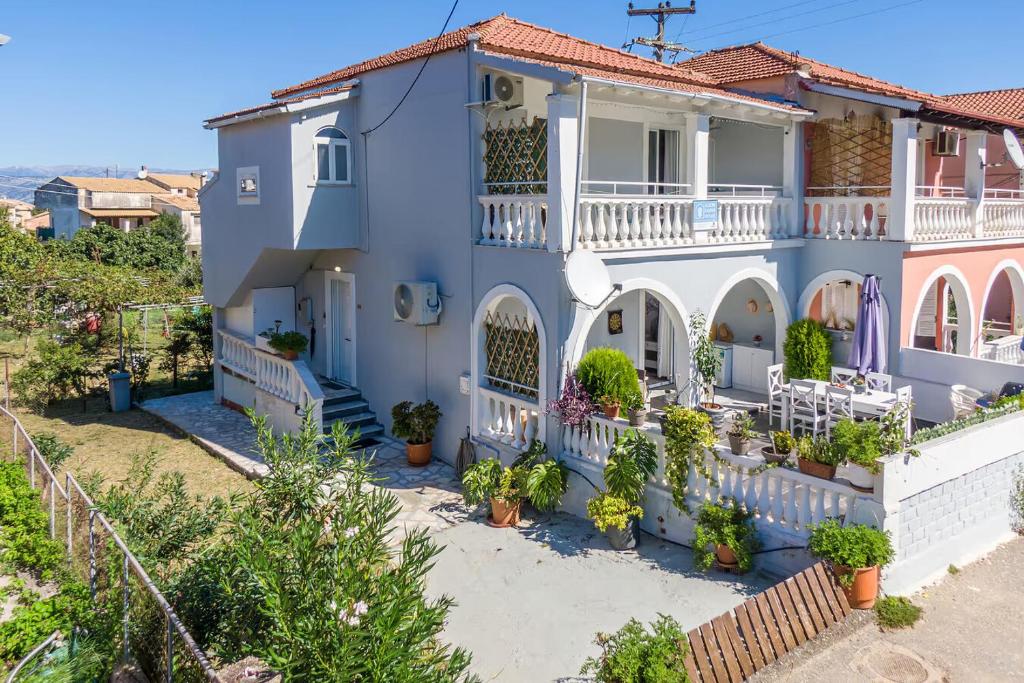 a blue house with a balcony and plants at Donna's luxury home in Kassiopi 300m from the sea in Kassiopi