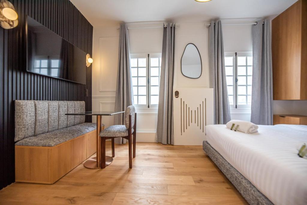 une chambre avec un lit, une table et une chaise dans l'établissement Luxury Studio - Louvre, Palais Royal - CIA, à Paris