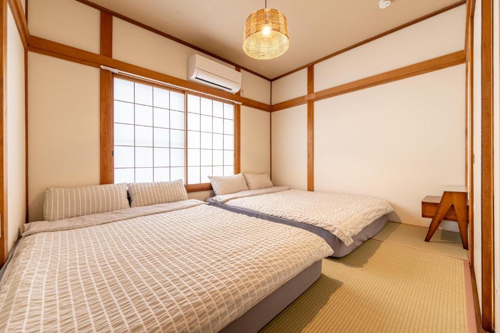 two beds in a room with two windows at 良居民宿 YOSHII House 晴空塔徒步圈 整栋出租 in Tokyo