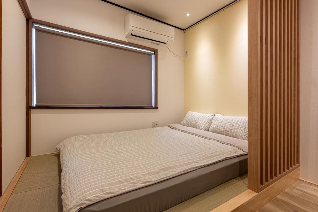 a small bedroom with a bed and a large window at 良居民宿 YOSHII House 晴空塔徒步圈 整栋出租 in Tokyo