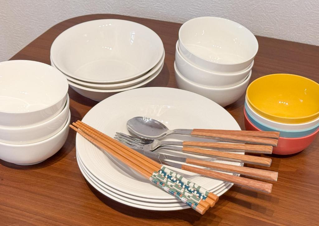 a table with white plates and spoons and bowls at 良居民宿 YOSHII House 晴空塔徒步圈 整栋出租 in Tokyo