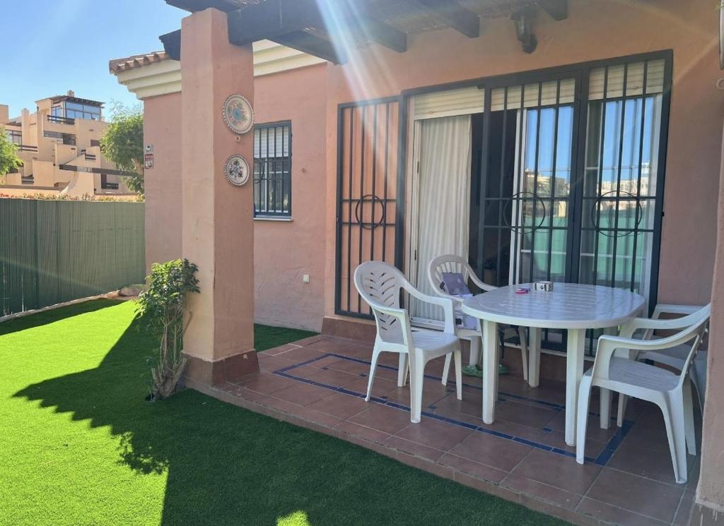a patio with a table and chairs on a lawn at Vera playa in Vera