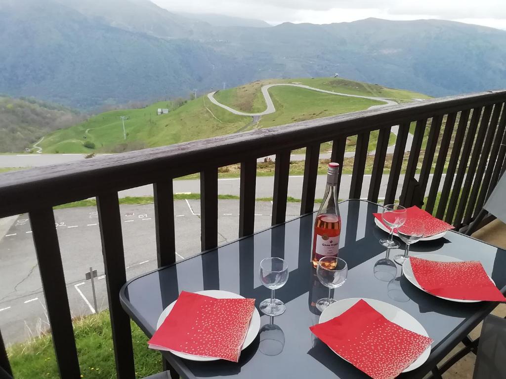 - une table avec des verres à vin et une bouteille sur le balcon dans l'établissement PEYRAGUDES BALESTAS T3 - 4-6pers - 2chambres, à Germ