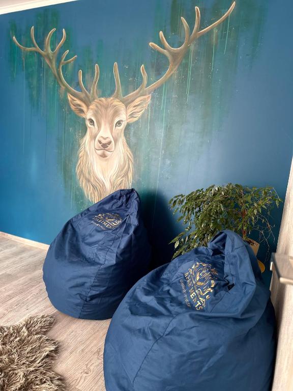 a painting of a deer on a wall with blue bags at Люкс апартаменти «Д.І.М.» in Kamianets-Podilskyi