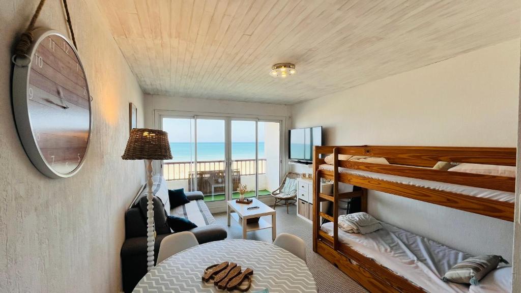 une chambre avec un lit superposé et un salon dans l'établissement L'horizon Océan, studio face mer, à Saint-Jean-de-Monts