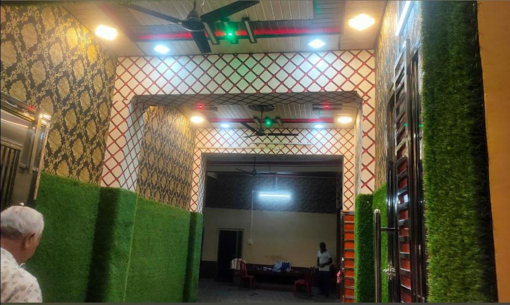 a room with a green wall and a person in a room at Krishna plaza in Sālpura