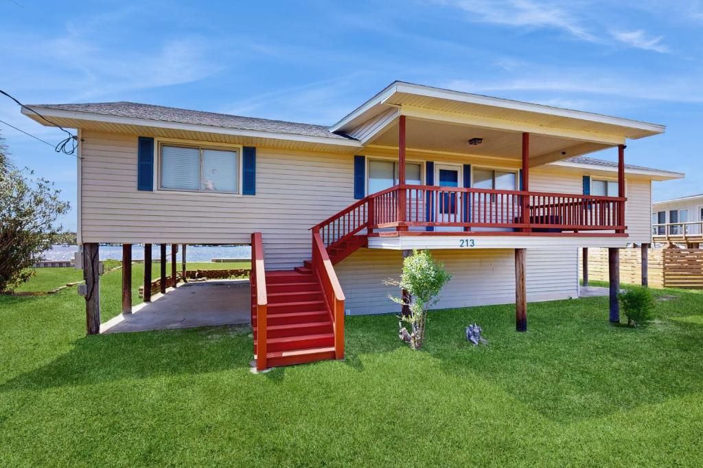 una casa con una escalera roja en el patio en Waterfront Oasis, en Carolina Beach