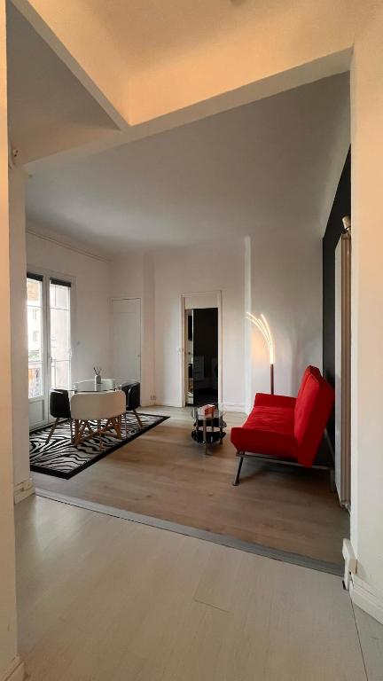 un salon avec un canapé rouge et une table dans l'établissement Appartement Cosy avec clim et Wi-Fi à 5 min de la gare TGV, à Toulon