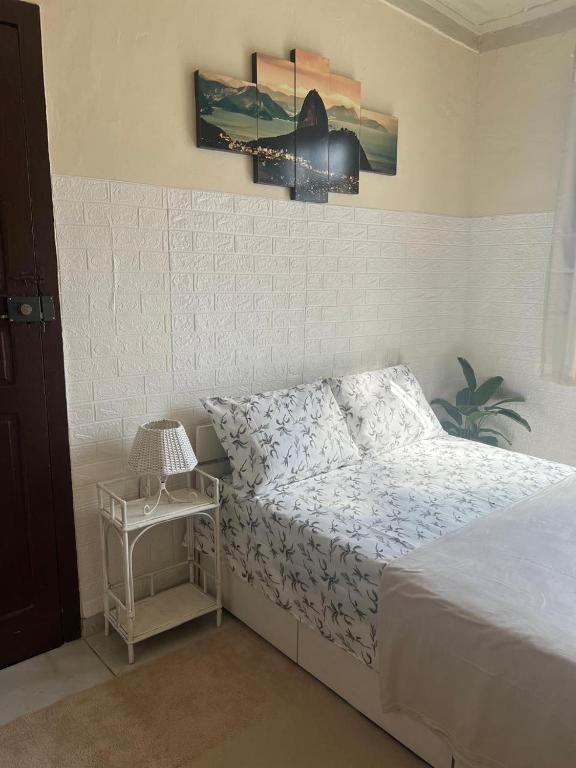 a bedroom with a bed and a table with a lamp at Bandeira do Brasil in Rio de Janeiro