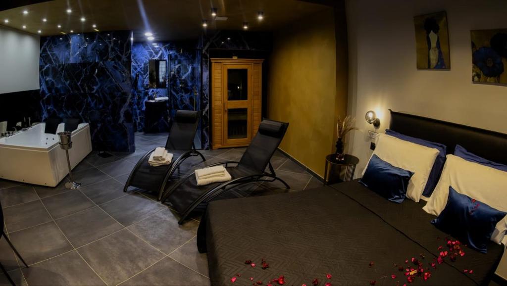 ein Schlafzimmer mit einem Bett, Stühlen und einer Badewanne in der Unterkunft Dea Suite in Bagheria
