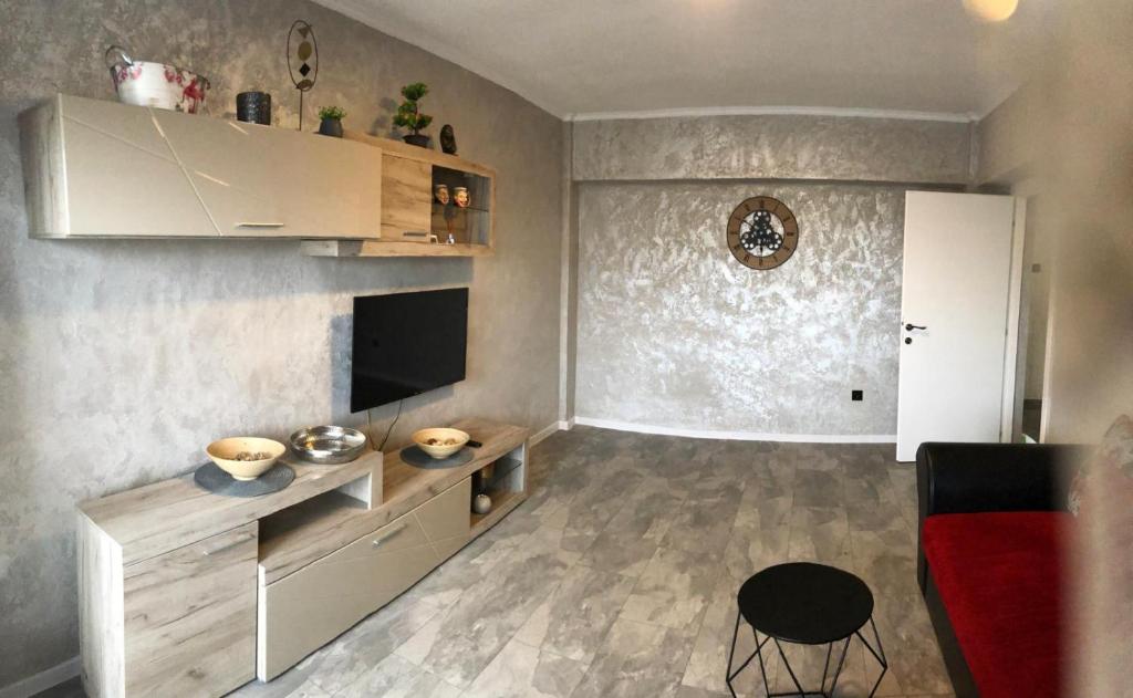 a living room with a fireplace and a red couch at Alfredo Apartament in Buzau