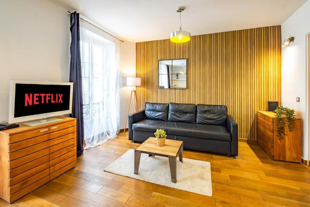 uma sala de estar com um sofá e uma TV em Bright apartment at Les Invalides - 4 Guests em Paris