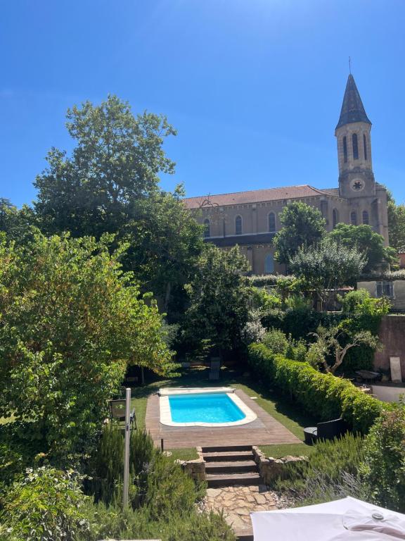 une piscine dans un jardin avec un bâtiment dans l'établissement Les Marrouges de Saint Jean, à Collobrières