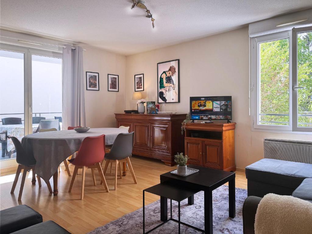 un salon avec une table et un canapé dans l'établissement Joli 3P avec terrasse et Garage proche Centre, à Strasbourg