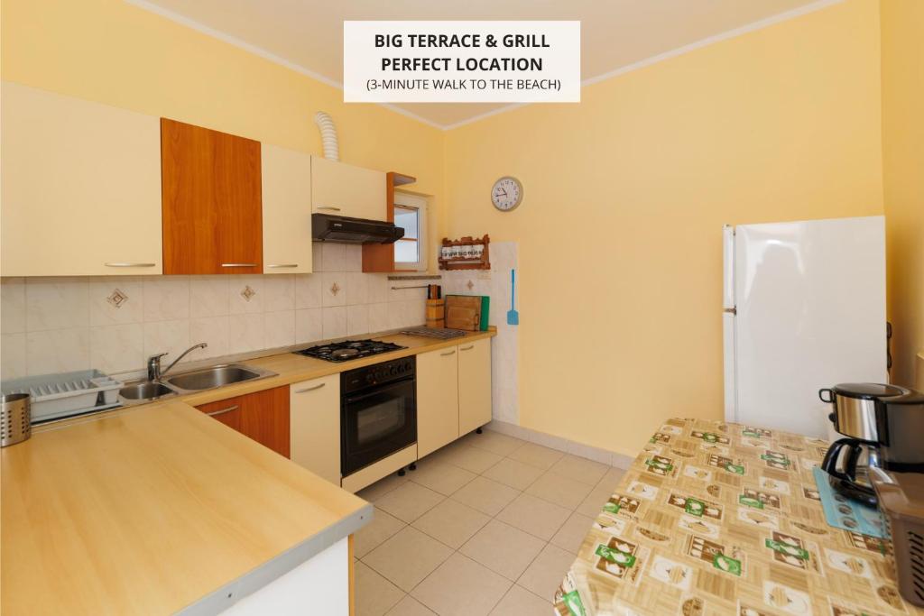 Una cocina con un refrigerador blanco y un fregadero. en Apartma Zara, en Rtina