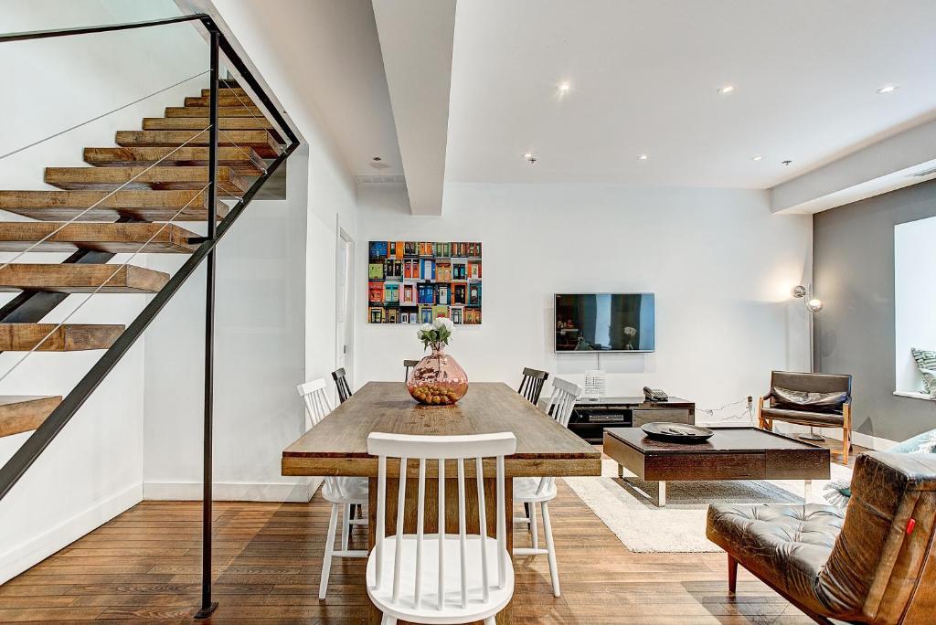 a dining room with a table and a staircase at The SFX Old Port in Montreal