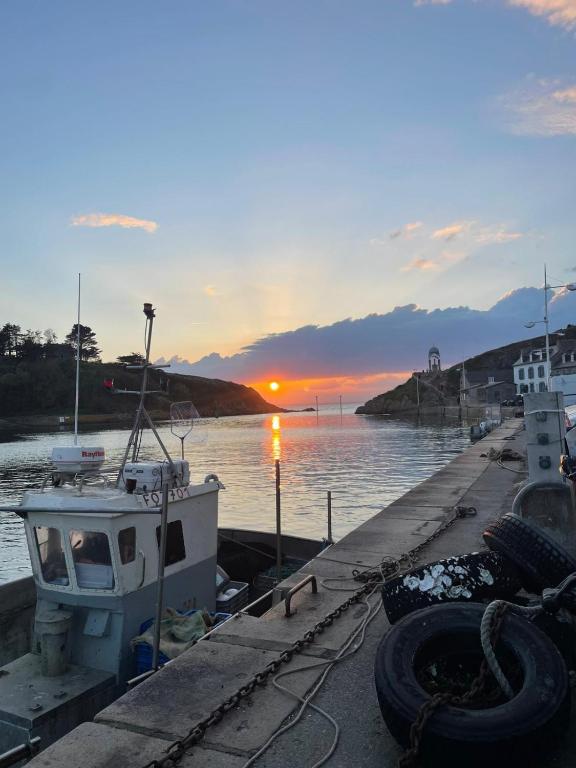 un bateau est amarré sur un quai au coucher du soleil. dans l'établissement Ty Dahouet Bretagne, à Pléneuf-Val-André