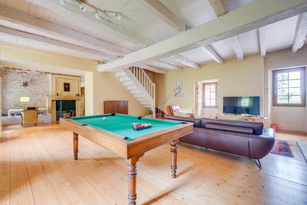 un salon avec une table de billard et un canapé dans l'établissement Charming home with a pool, à Blasimon