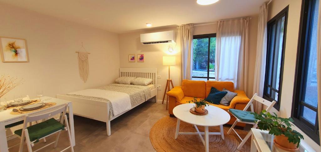 a small room with a bed and a living room at מקום להיות סוויטה אדריכלית זוגית in Bet Qeshet