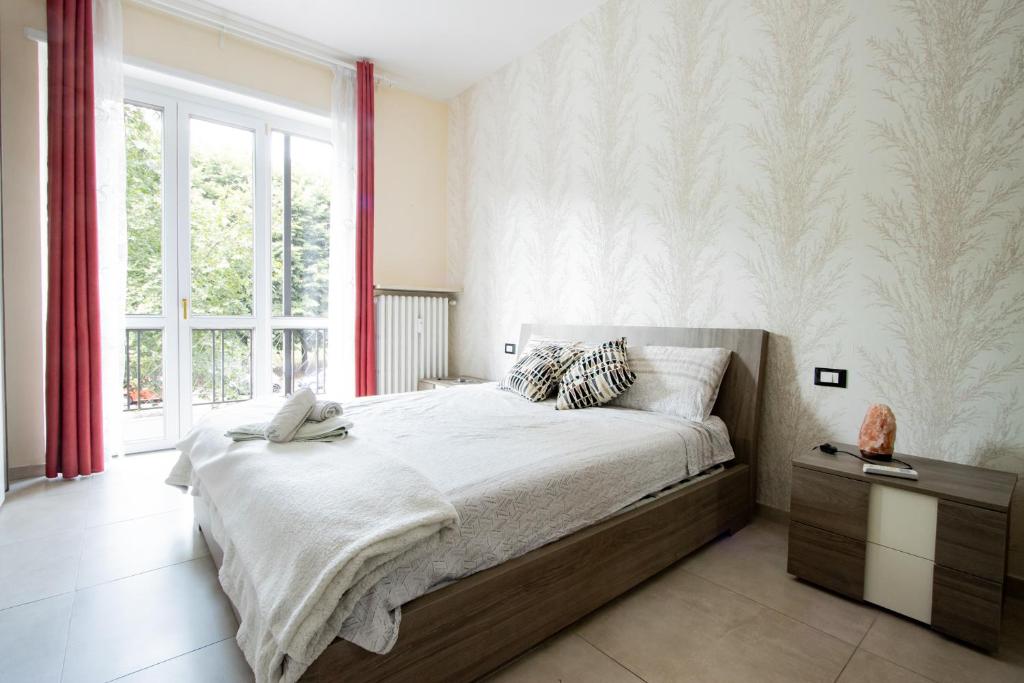 a bedroom with a large bed and a window at [Reni House]-Bright apartment+free park in Turin