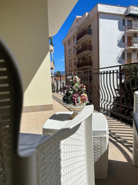 a vase of flowers sitting on a table on a balcony at Saturno Casa Vacanza in Milazzo