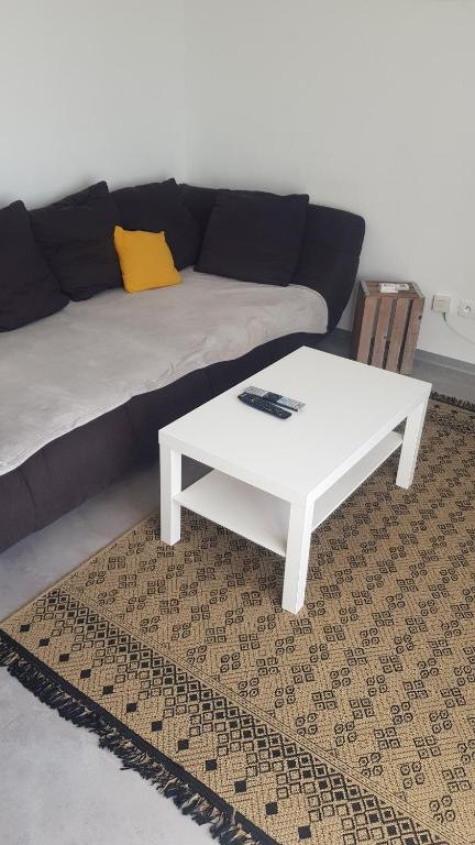 - un salon avec un canapé et une table basse blanche dans l'établissement Large single-family home with 4 large bedrooms, à Montbéliard