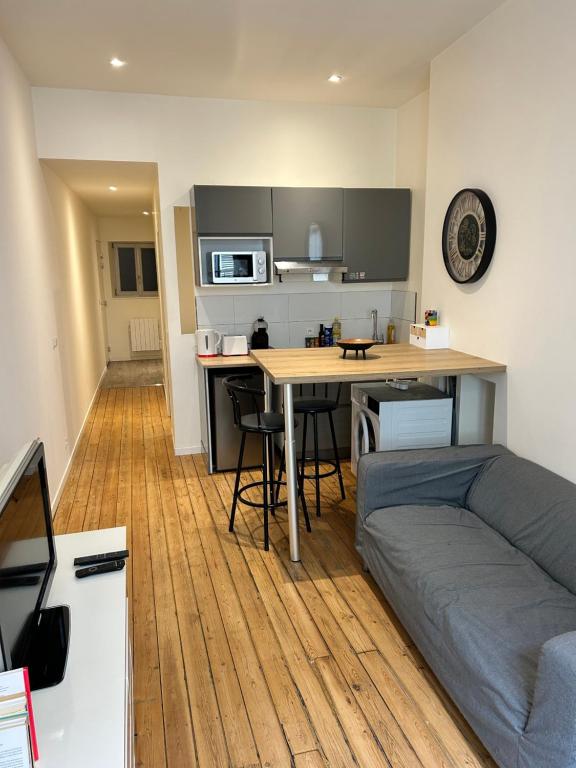 a living room with a table and a couch at Studio au centre ville de Dole in Dole