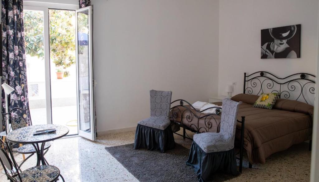 a bedroom with a bed and two chairs and a table at Residence Prato in Trapani