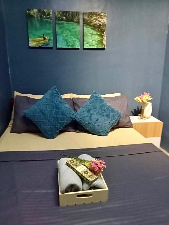 a bed with a box on it with blue walls at Balai Evelyn Homestay in Coron