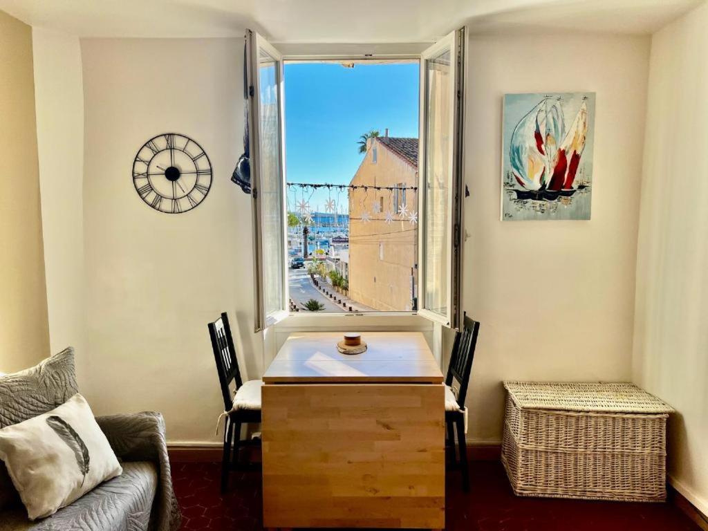 un salon avec une table et une fenêtre dans l'établissement Appartement T2 - Côté port au coeur de Bandol, à Bandol