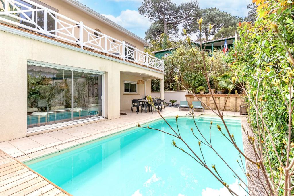 une piscine dans l'arrière-cour d'une maison dans l'établissement Villa Fleurs des Pins, piscine chauffée , 80 m de la plage Pereire, à Arcachon