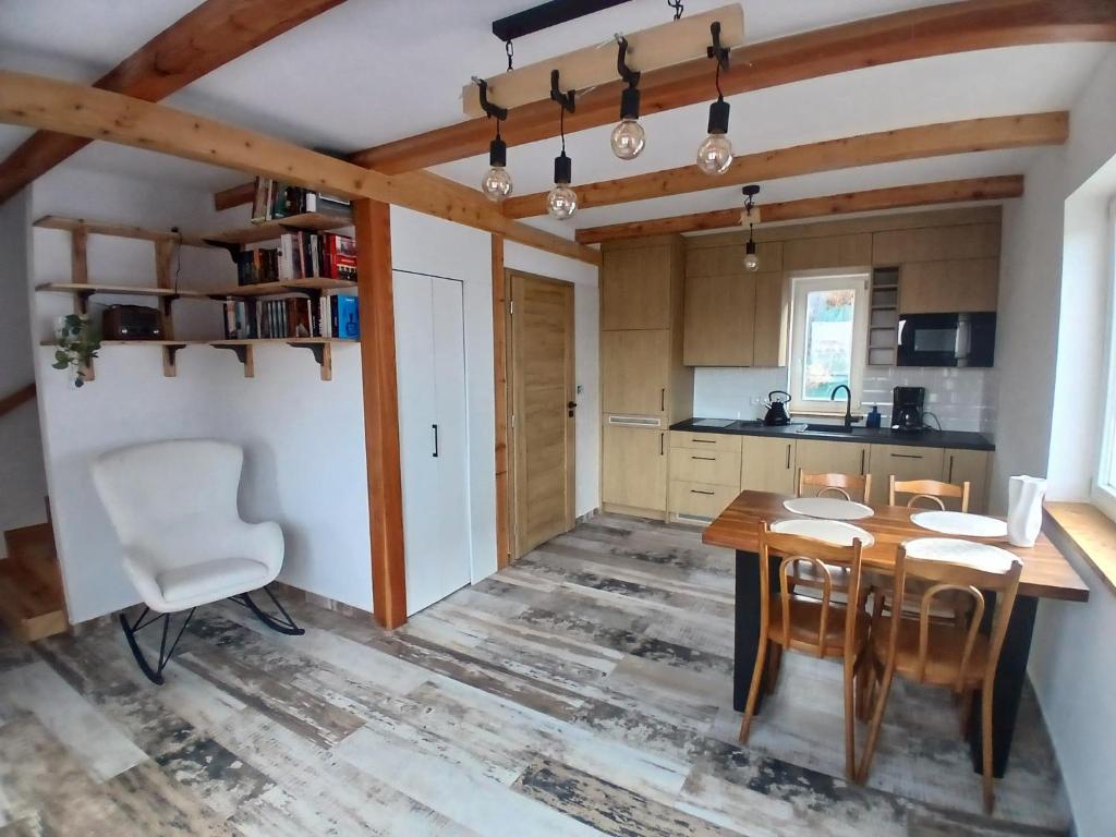 a kitchen with a wooden table and chairs at Dydusiowe Tarasy Górska Willa z Widokiem i Ogrodem Idealna dla Rodzin in Tylmanowa