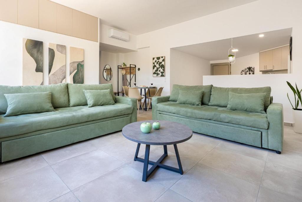 a living room with two green couches and a table at Cozy Light Nest Chania Crete in Kounoupidhianá