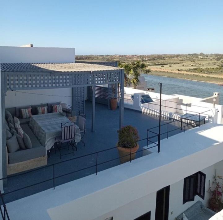 a balcony with a couch and chairs on a building at Riad Azama in Azemmour