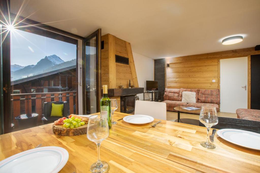 une salle à manger avec une table et des verres à vin dans l'établissement Comfortable and Spacious Morzine Apartment, à Morzine