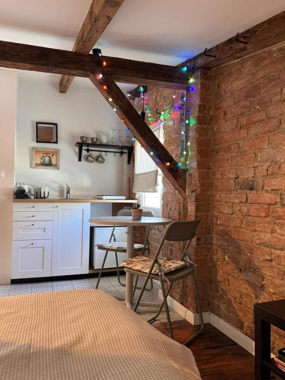 een keuken met een tafel en een bakstenen muur bij Pocztówka Spod Dachu in Sopot