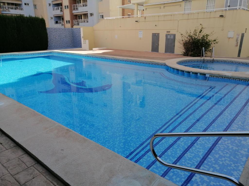 ein großer blauer Pool in einem Gebäude in der Unterkunft Bonita piscina y playa de gandia in Puerto de Gandía